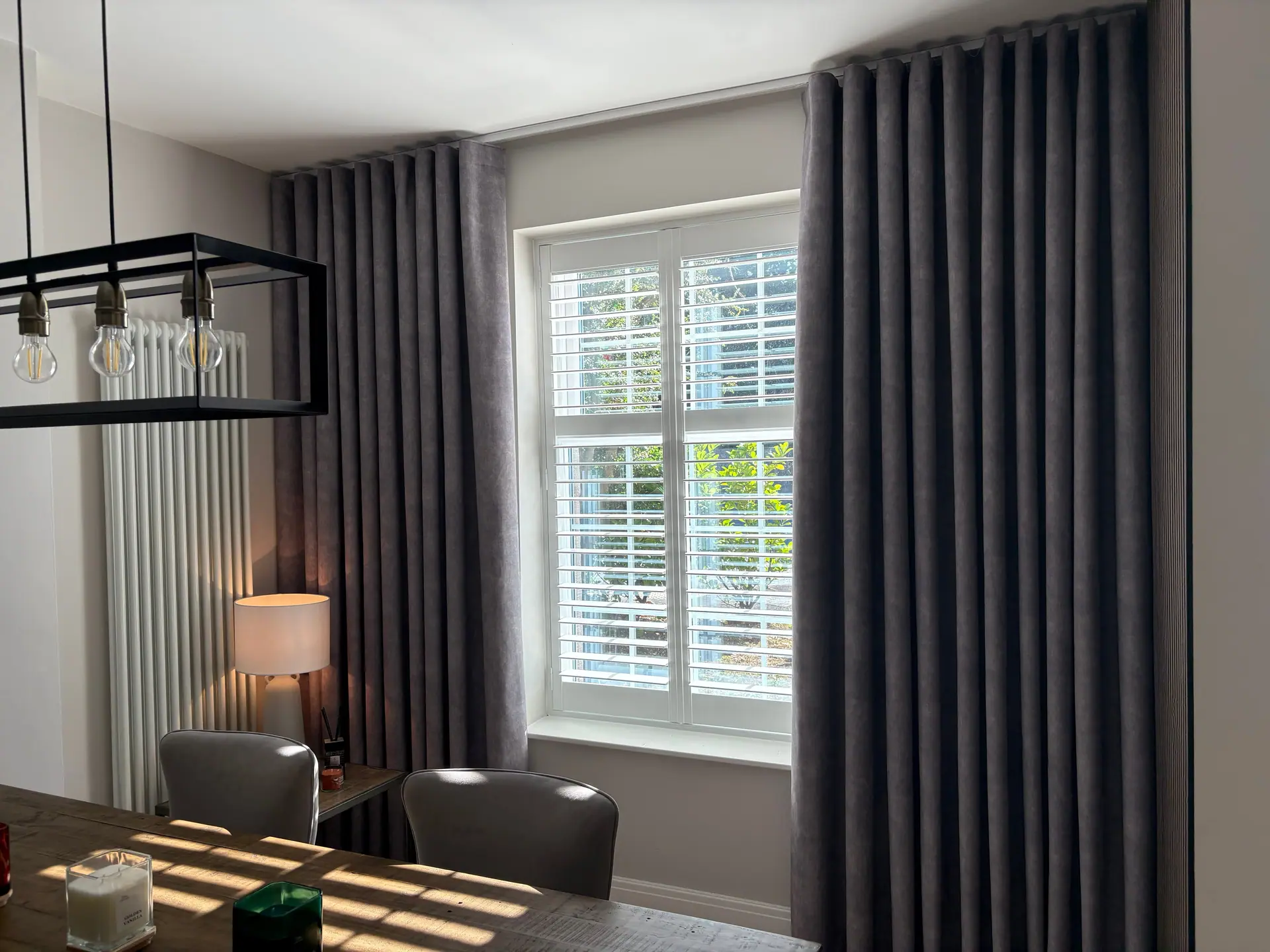 A bright living room with made-to-measure curtains at floor-to-ceiling windows