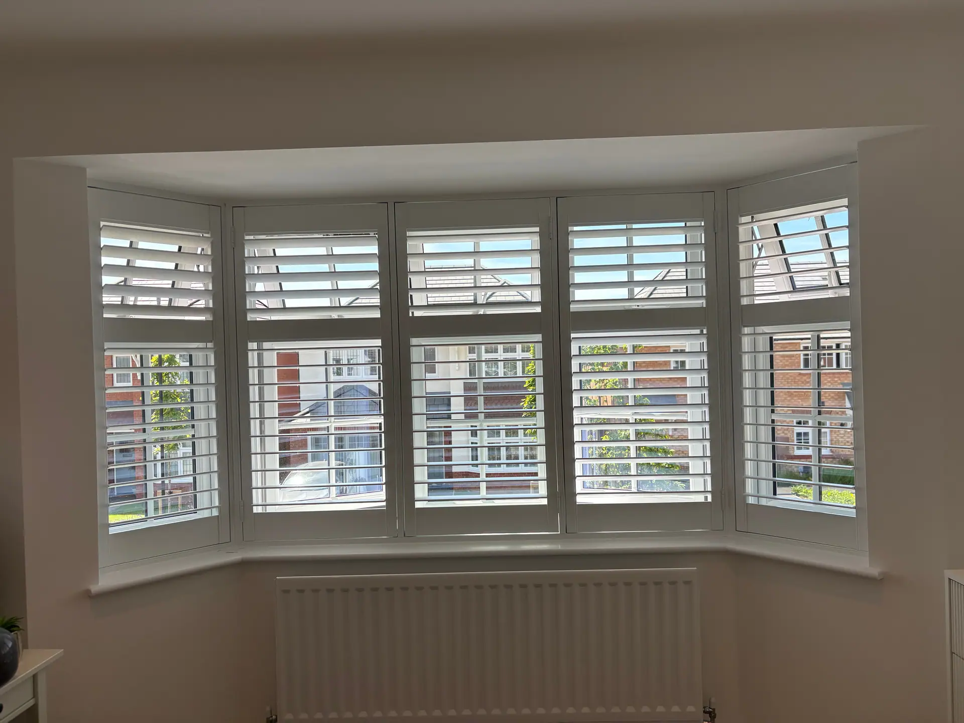 White tier-on-tier shutters fitted to a bay window